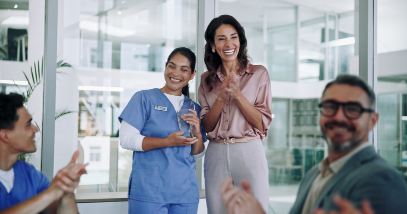 Happy nurse, award and team with applause for congratulations, celebration or achievement at hospital.